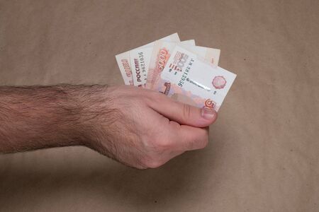 Male hand with russian money studio image. Man's hand holds Russian rubles. Male hand with money.