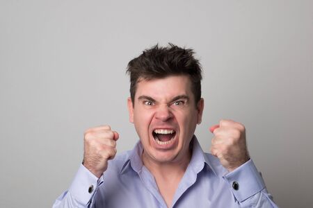 Angry young man. Screaming business man.の写真素材