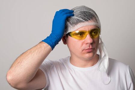 Doctor in a surgical mask, gloves and glasses. Surgeon before the operation. Young man in a medical...