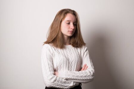 Sad teenager girl. Studio image of a cute young girl on a gray background.の写真素材