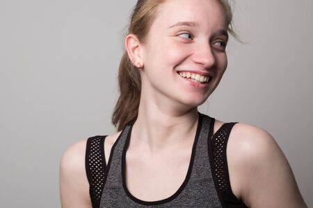Smiling young girl is engaged in fitness. Teen girl in sportswear. Sport girl in tank top for yoga.の写真素材