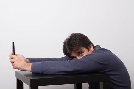 Man in pajamas chatting with friends online. Positive man shopping online from home.の写真素材