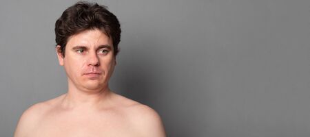 Portrait of a handsome naked man on gray background is going to have a shower.の写真素材