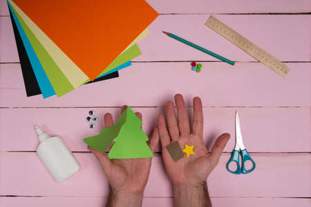 How to make christmas card from color paper with children. Step by step instructions. Handmade DIY new year holiday decoration project. Top view. Step 3の写真素材