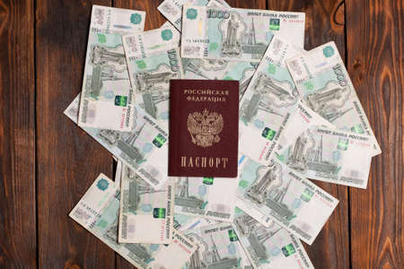 Russian passport with money for shopping abroad, travel and entertainment. Money is lying on wooden background.の写真素材