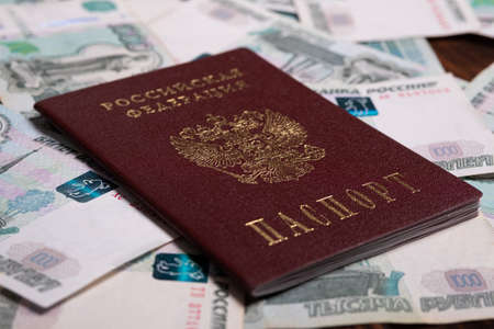 Russian passport with money for shopping abroad, travel and entertainment. Money is lying on wooden background.の写真素材
