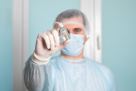 Male doctor, scientist, researcher hand in medical gloves holding flu, measlesの写真素材