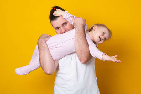 Portrait of young father hugging his baby daughter.の写真素材