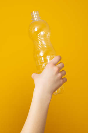 We are against plastic garbage. Hand clutches an empty disposable bottle. Separation of waste, recycling of plastics.の写真素材