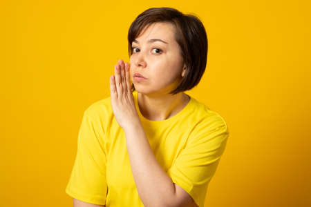 Charming woman have wonderful  unbelievable news promo want tell friends quiet isolated wear modern youth clothing yellow backgroundの写真素材