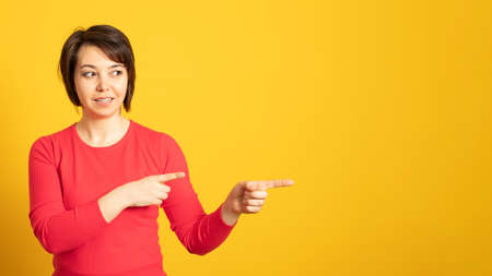 Banner. Pleased woman points away with both fore fingers, shows blank space for your promotion,...