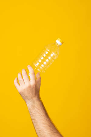 We are against plastic garbage. Hand clutches an empty disposable bottle. Separation of waste, recycling of plastics.の写真素材