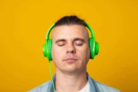 Man listening to music using headphones looking to side, relax profile pose with natural face.の写真素材