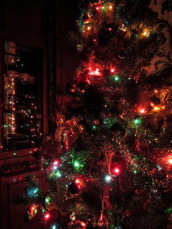 Christmas tree decorated with a garland and colorful lights in the house. Vertical.の写真素材