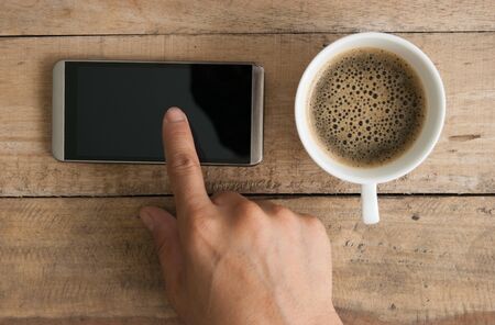 hand using smartphone on wood table