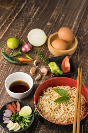 Noodles with sauce or shoyu and ingredient on table wood backgroound in close up.の写真素材