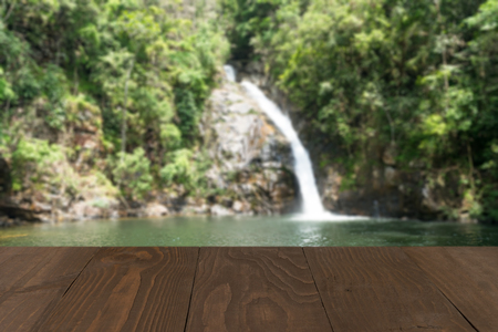 Wooden board empty table in front of blurred waterfall backgroundの写真素材