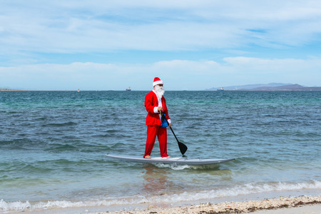 Santa Claus approaches the shore of the beach on table.の写真素材