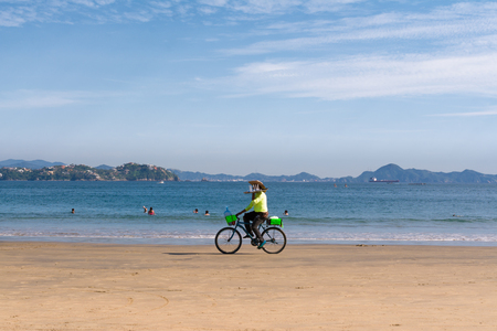 The seller by bicycle carries the tray on the beach.のeditorial素材