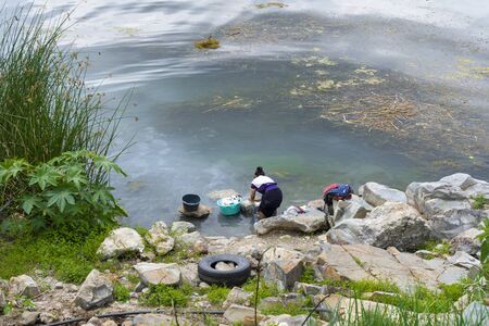 Mayan woman washes clothes in Lake Atitlan Guatemala.の写真素材