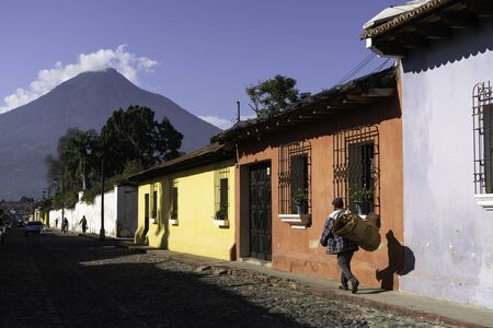 A man walks with his flowers on a street in Antigua Guatemala.の写真素材