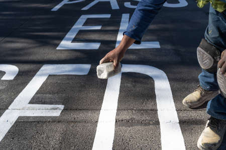 The worker is putting chemicals on the traffic paint.の写真素材