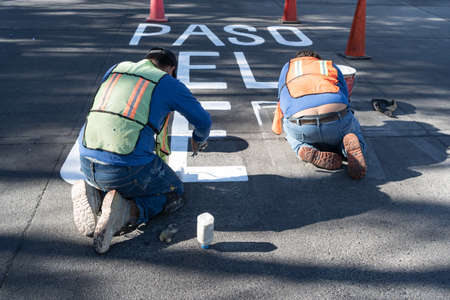Two workers are finishing making the traffic signs for the street.の写真素材