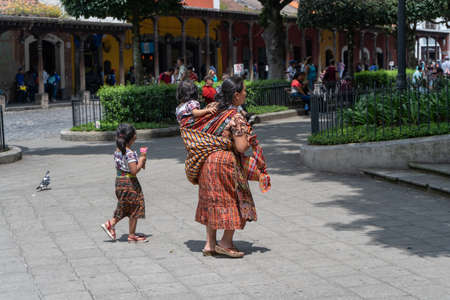 Antigua Guatemala, Guatemala - October 05 2019: A woman is walking with her children through a square in Antigua Guatemala.のeditorial素材