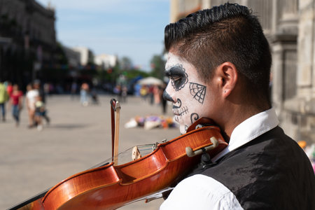 Guadalajara Jalisco - November 01, 2019: The mariachi catrin is playing his violin outside the Guadalajara Cathedral.のeditorial素材
