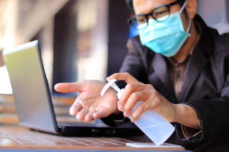 Asian businessmen Wear medical mask for coronavirus covid-19 protection working in office, coronavirus covid-19 outbreak control, Clean hands with a cleaning gel.の写真素材