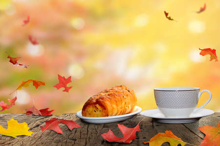 Coffee cup and breakfast and autumn maple leaves are on a wooden tableの写真素材