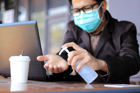 Asian businessmen Wear medical mask for coronavirus covid-19 protection working in office, coronavirus covid-19 outbreak control, Clean hands with a cleaning gel.の写真素材