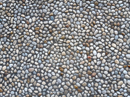 Colorful and round stones, stone wall texture, road made of small boulders and sea stones.の写真素材