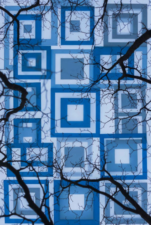 abstract background with blue and white pattern on the wall and tree branchesの素材