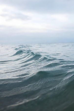 Close up of sea water surface with waves and clouds in the backgroundの素材