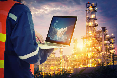 Service engineer working with laptop in Oil Refineryの写真素材