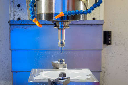 cnc metal working machine with cutter tool during metal detail milling at factory