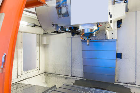 cnc metal working machine with cutter tool during metal detail milling at factoryの写真素材
