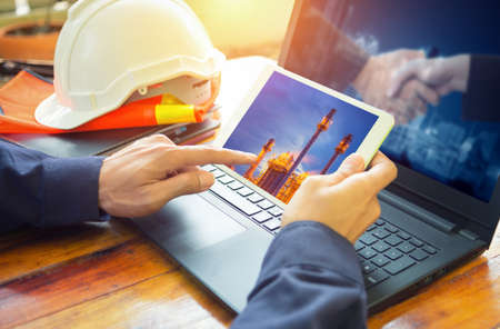 Service engineer working with laptop in Oil Refineryの写真素材