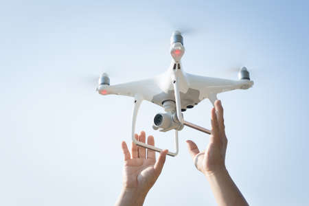 The drone and photographer man hands , The drone with the professional camera takes pictures.