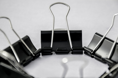 A bunch of black paper clips arranged in circular patternの写真素材