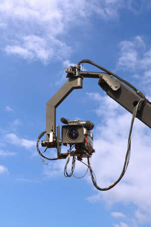 professional tv camera on a crane with blue skyの写真素材