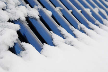 blue bars of a solar heating system under the snow coverの写真素材