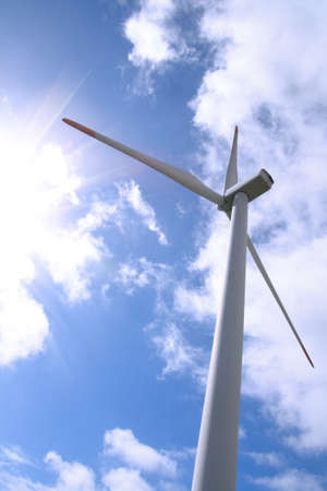 a wind enorgy turbine against sunny sky background
