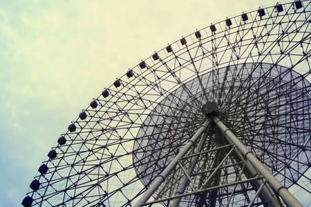 a big ferris wheel on the cloudy sky の写真素材