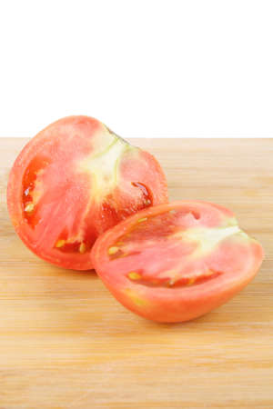 the cut tomato on cutting board with white backgroundの写真素材