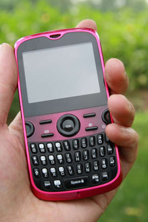 a pink cell phone in hand with blank screenの写真素材