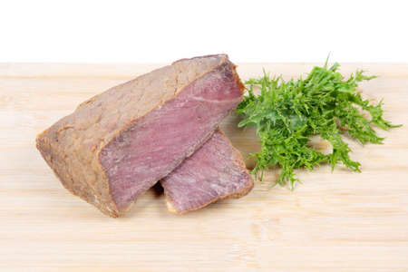 cooked  ribeye beef and green vegetables leaves on the chopping boardの写真素材