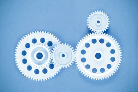five gears meshing together over blueの写真素材