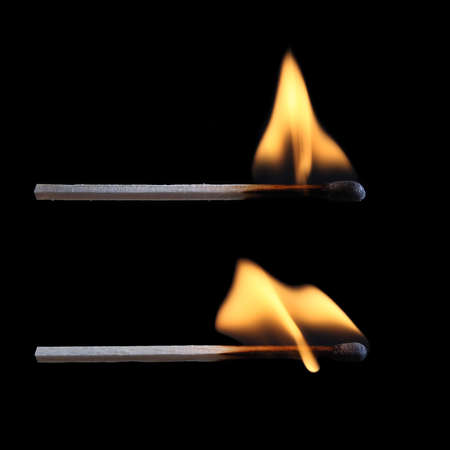 two burning matches with black background の写真素材